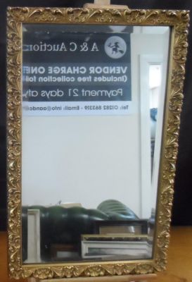 Oblong, bevelled edged mirror in ornate gilt frame