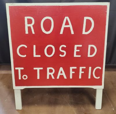 A hand painted road closure sign