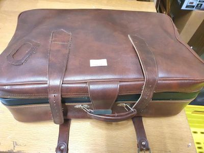 Large brown soft leather suitcase full of clean ladies clothes