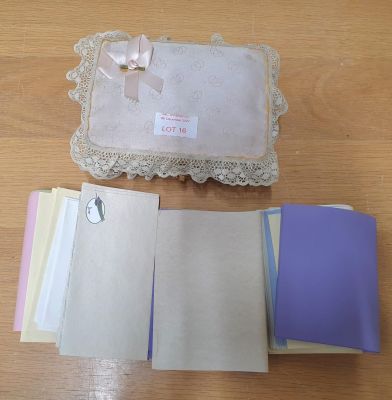 Cloth covered small wicker box containing pastel coloured writing paper and envelopes