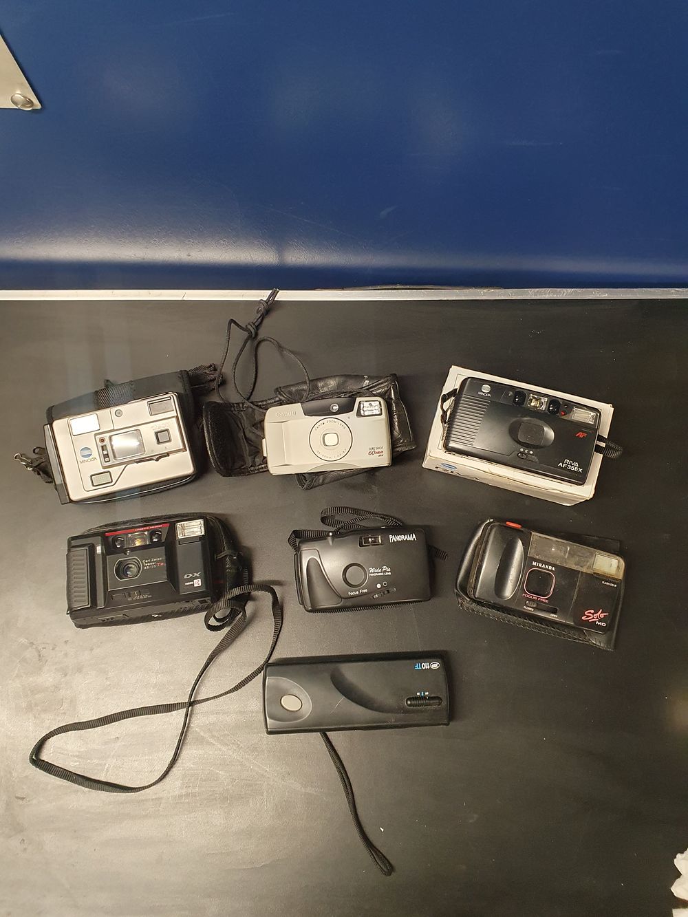 Lot 166: A Collection of Seven Vintage Compact and Point-and-Shoot Cameras including Kyocera Minolta and Canon Models