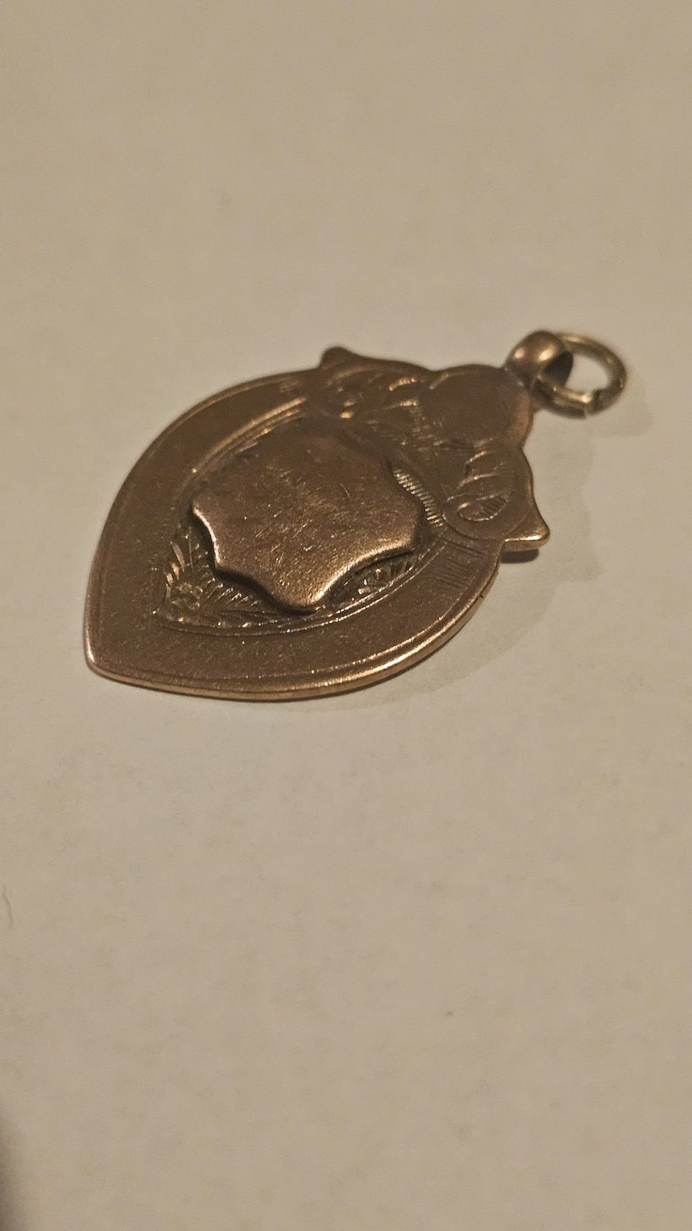 Lot 201: A 1923 Birmingham 9 Carat Gold Shield-Shaped Boxing Award Pendant by William Hair Haseler. 5.7g