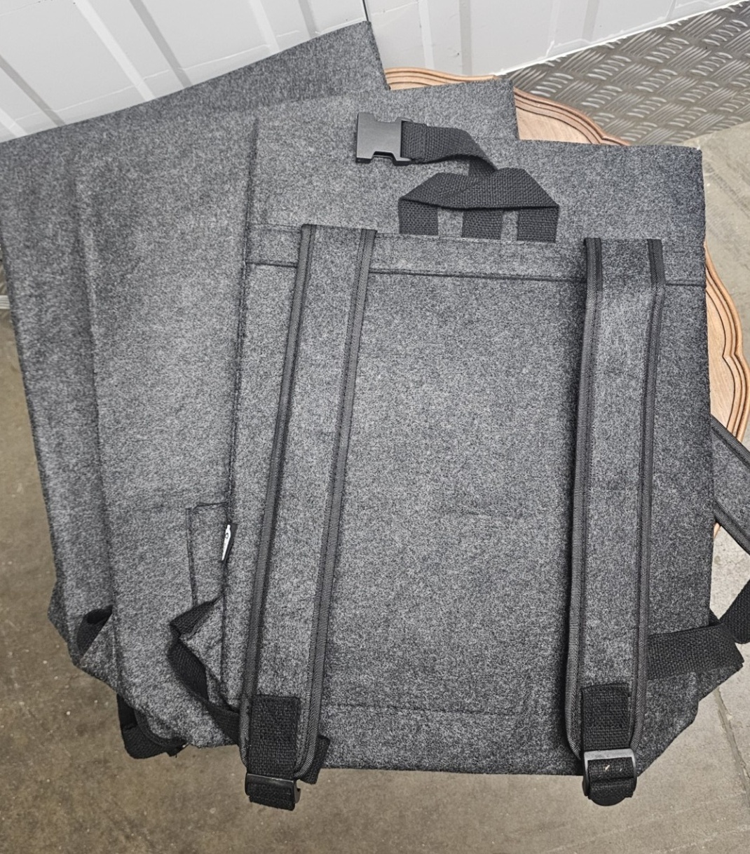 Three minimalist grey felt backpacks
