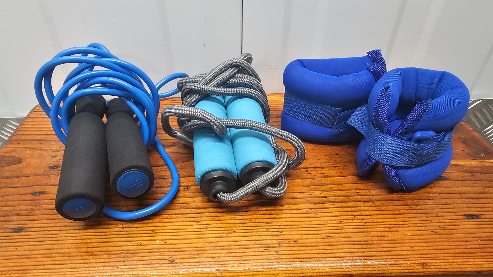 A Trio of Fitness Equipment Including Two Jump Ropes and a Pair of Weighted Straps