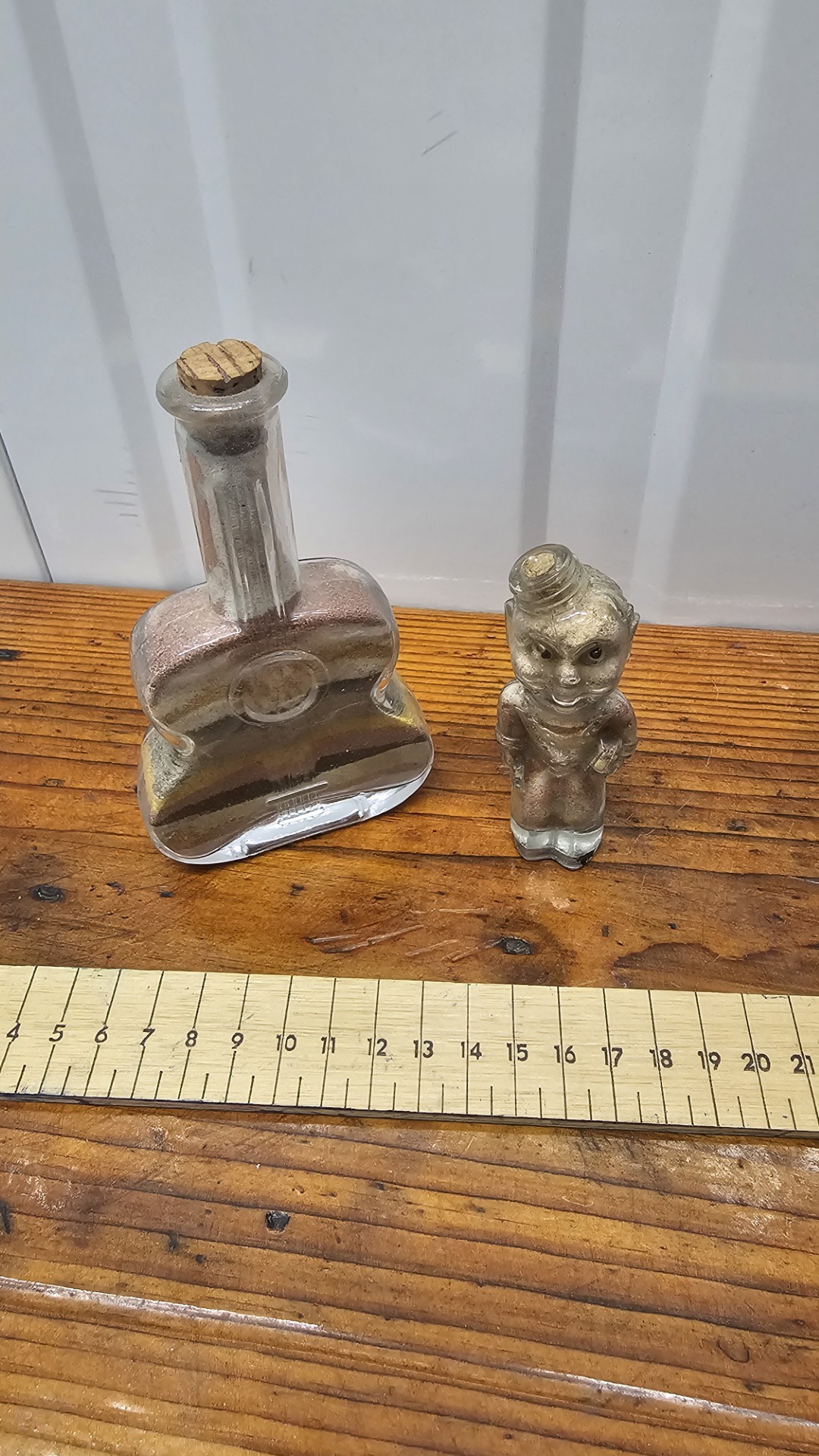Two Vintage Glass Souvenir Sand Art Bottles, including Guitar-Shaped and Character Figurine Examples