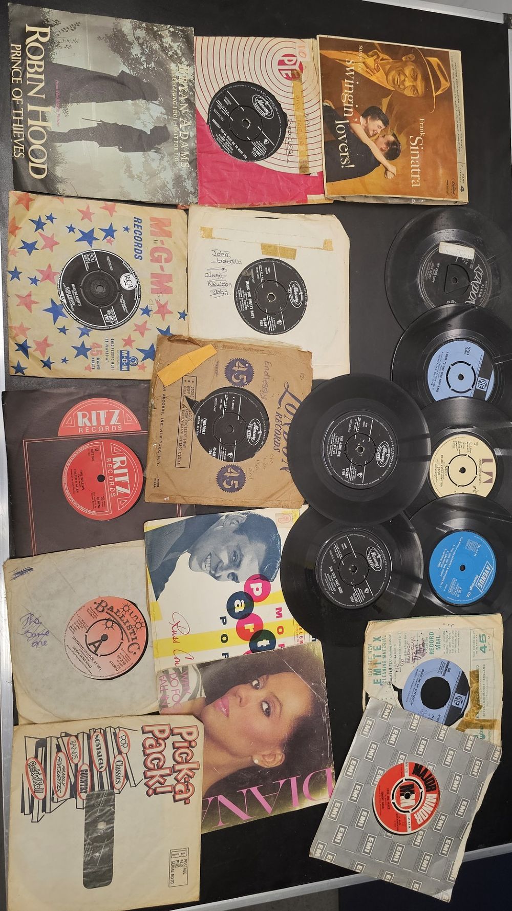 Lot 275: An Assortment of Vintage 45 RPM Vinyl Records and Sleeves Including Bryan Adams and Frank Sinatra