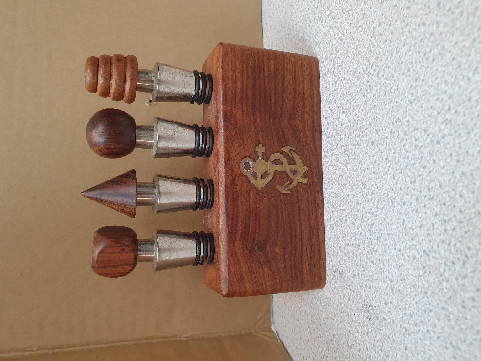 A Set of Wood and Metal Wine Stoppers with a Nautical Motif Wooden Stand