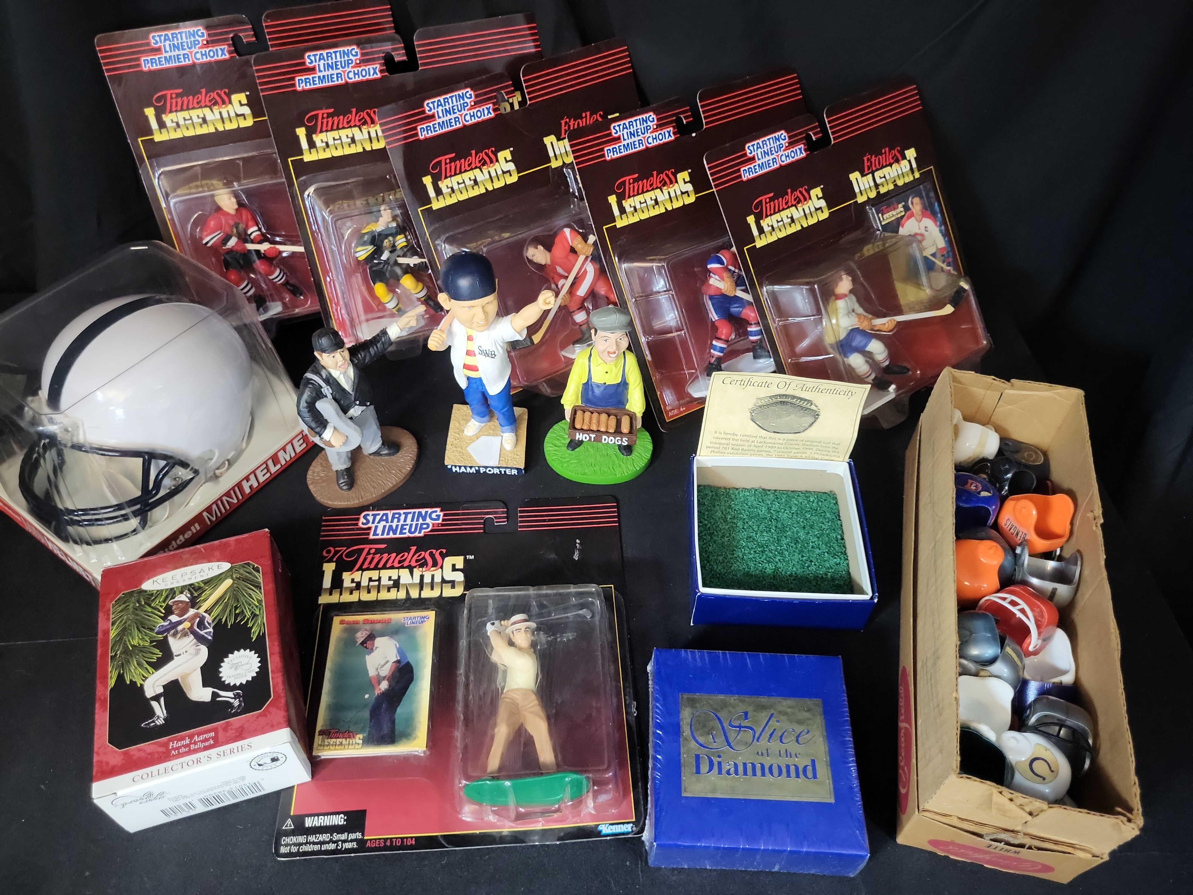 I03054 | An Assortment of Sports Memorabilia including Starting Lineup Figures, Bobbleheads, and Stadium Relic