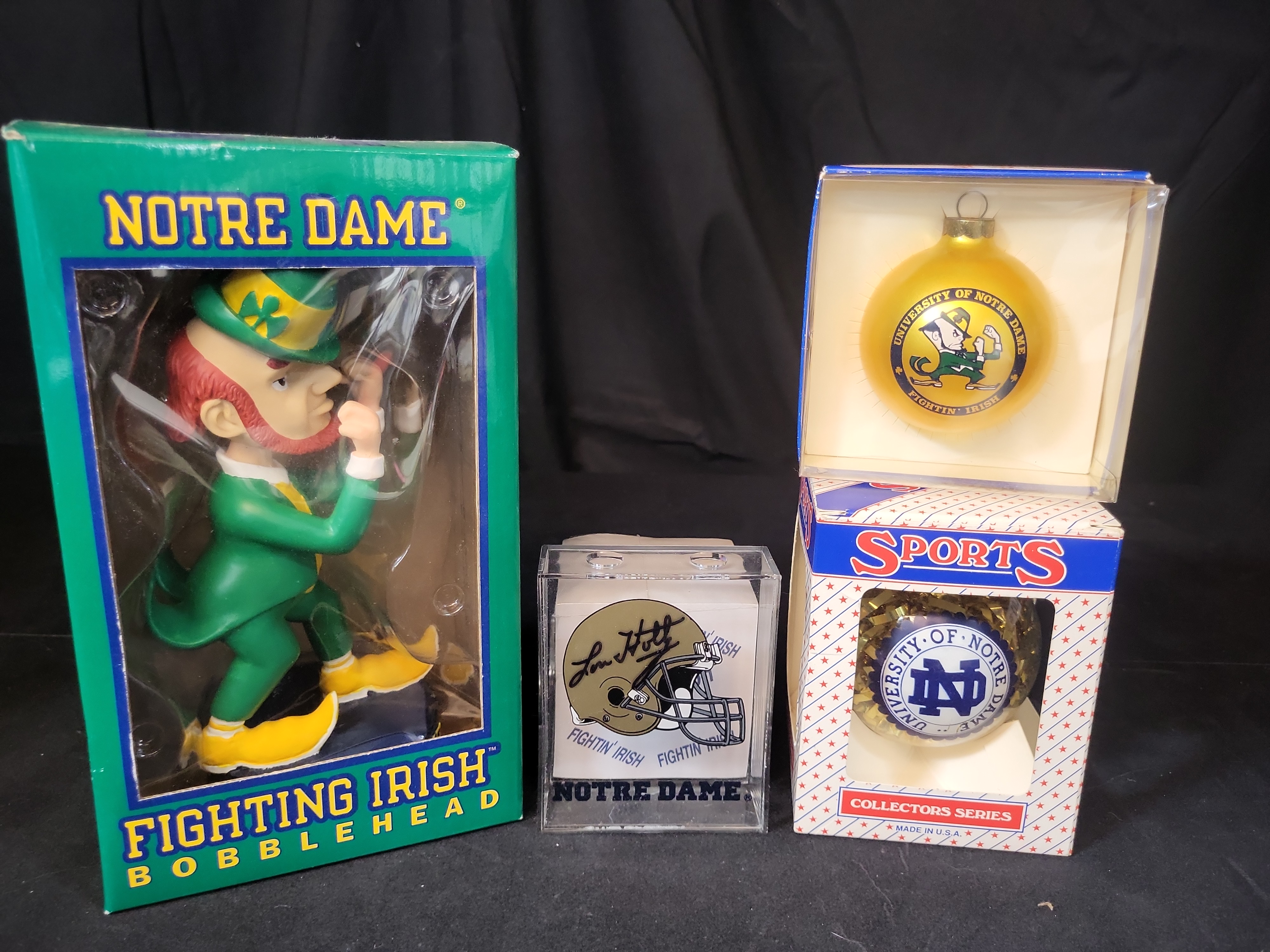I03056 | A Collection of Four University of Notre Dame Fighting Irish Collectibles Including a Lou Holtz Signed Desk Accessory