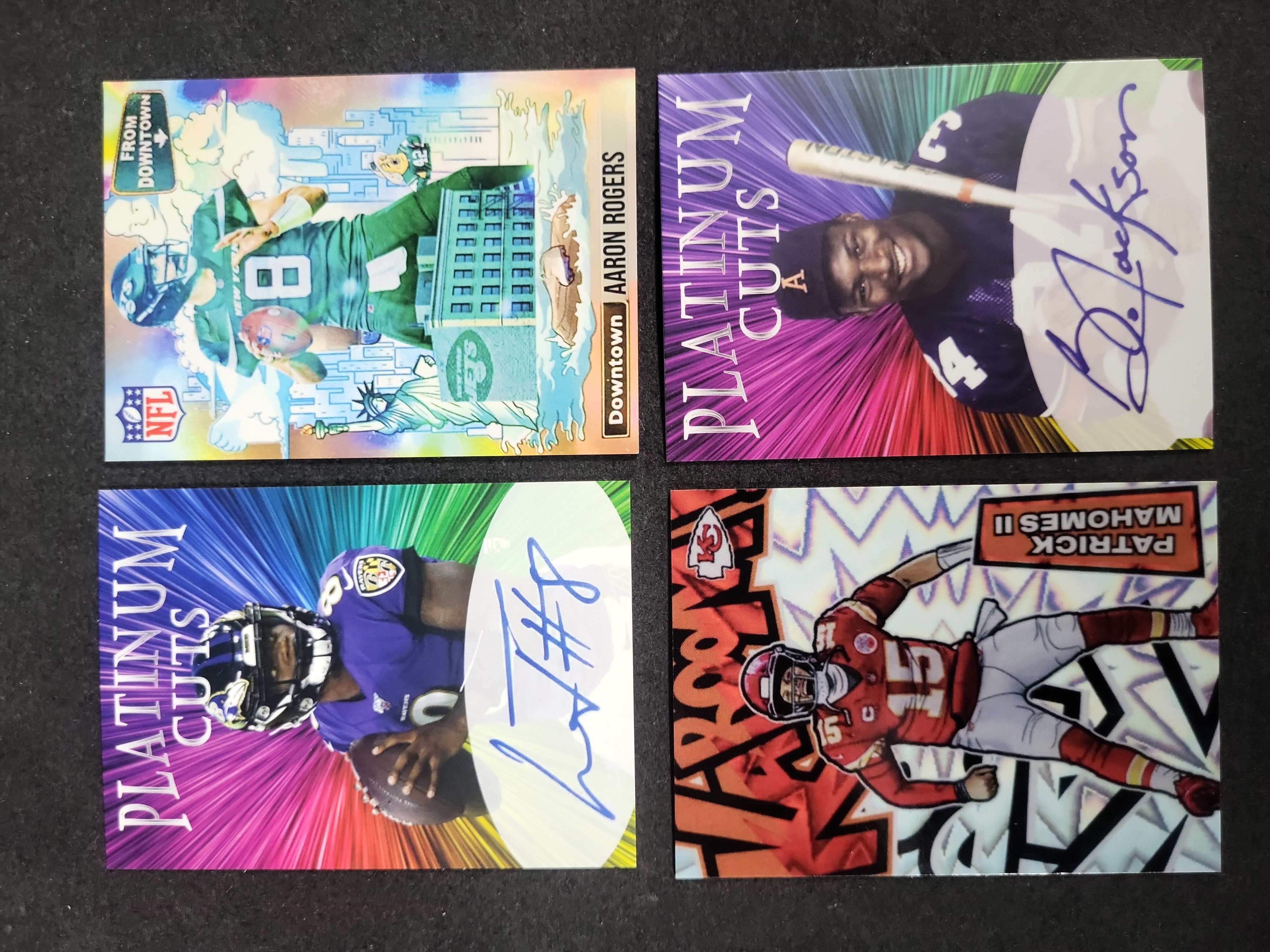 I03602 | A Collection of Four Modern Football Trading Cards Featuring Aaron Rodgers, Patrick Mahomes II, Bo Jackson, and Lamar Jackson