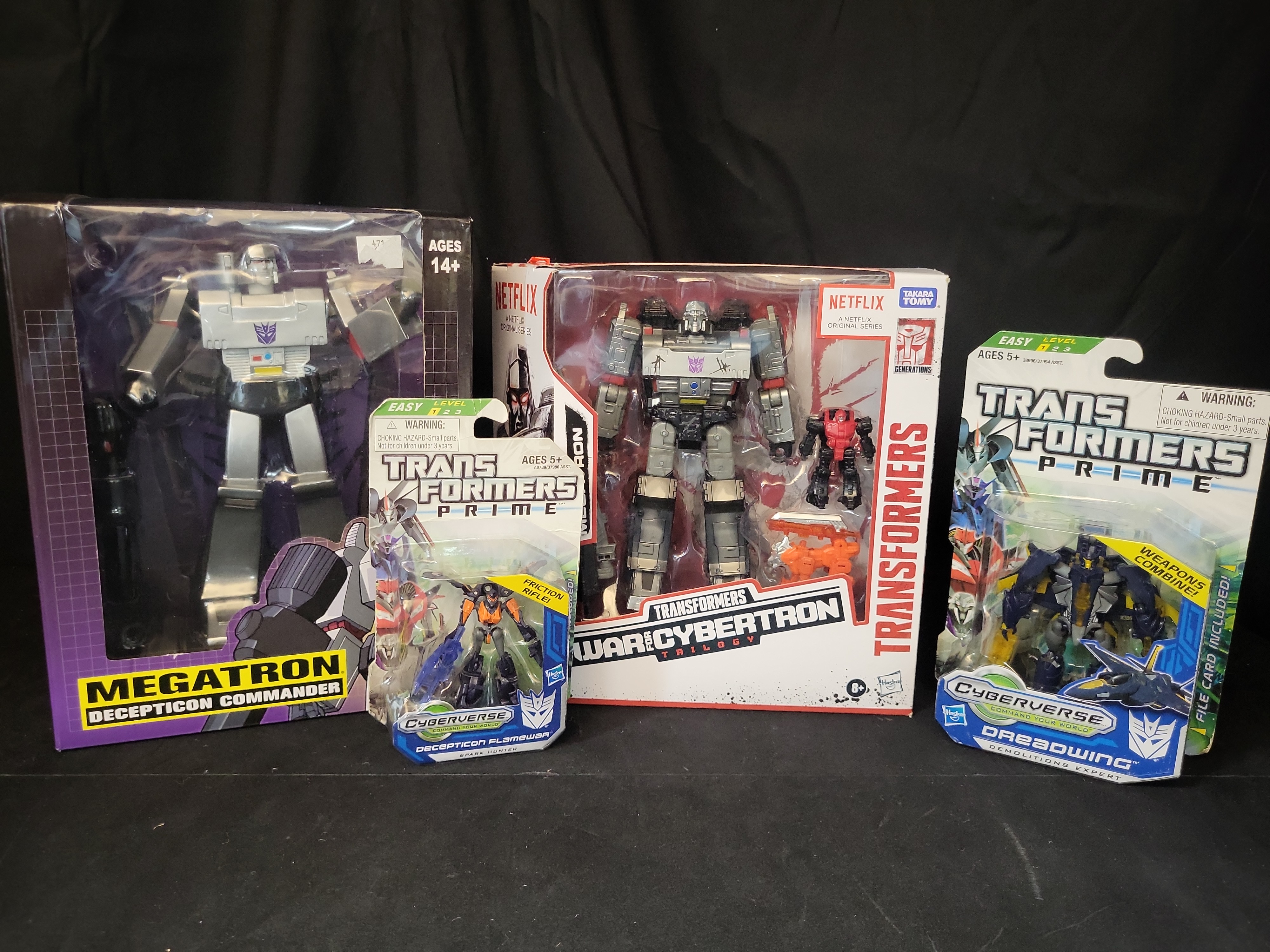 I03502 | A Collection of Four Hasbro and PCS Collectibles Transformers Action Figures in Original Packaging