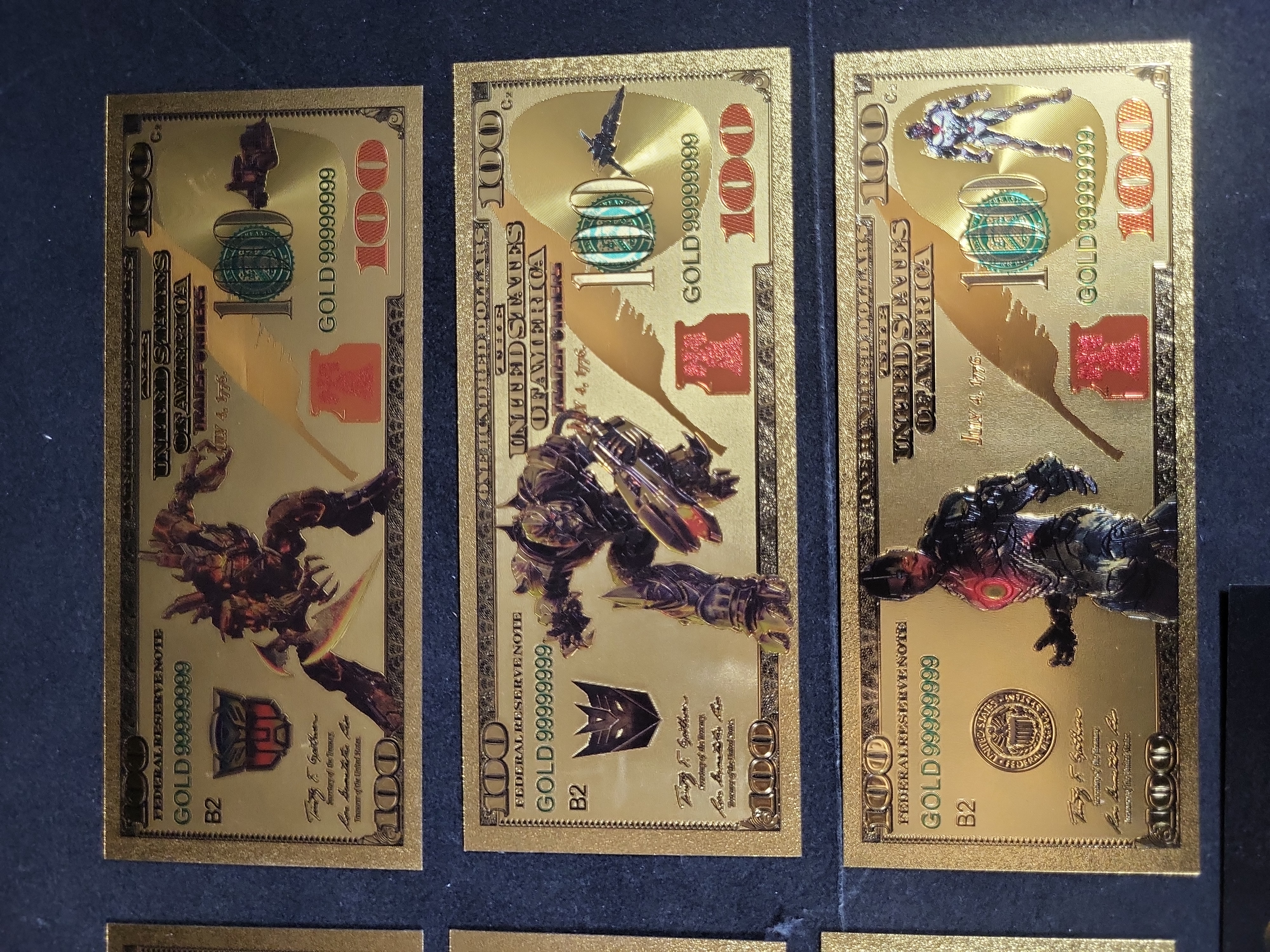 I03653 | Seven Novelty Gold Foil Banknotes Featuring G.I. Joe, Transformers, The Smurfs, and Cinematic Characters