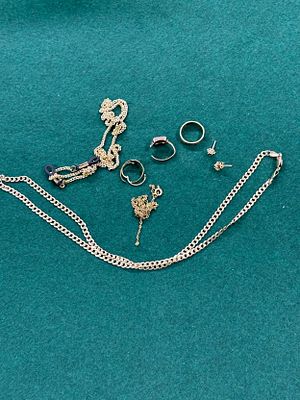 A vintage jewellery box containing a selection of yellow metal HM gold and plated costume 