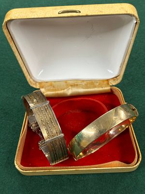 Two vintage bangles, one being yellow metal, the inside stamped "9 ct metal core"