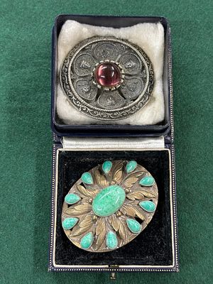An Indian White metal circular brooch and and oval, green stoned brooch
