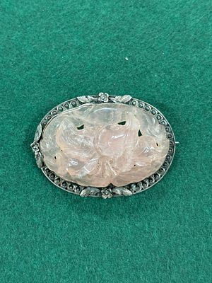 A vintage white metal brooch with a rose quartz inset