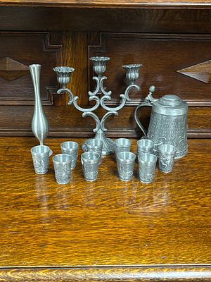 A pewter beer stein, ten shot glasses, three armed candleabra and bud vase