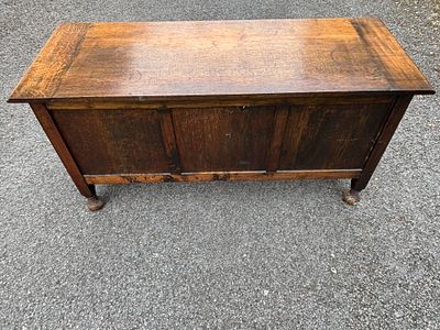 An early 19th century oak coffer, blanket box having panel decoration and bun feet. 123 cm wide