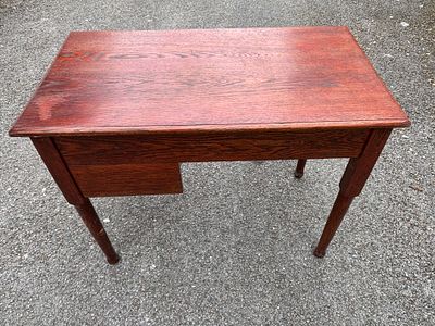 An early 20th century stained oak kneehole desk, with two drawers and turned legs 92 cm wide