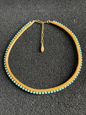 A yellow metal necklace having hook clasp and turquoise colored stones