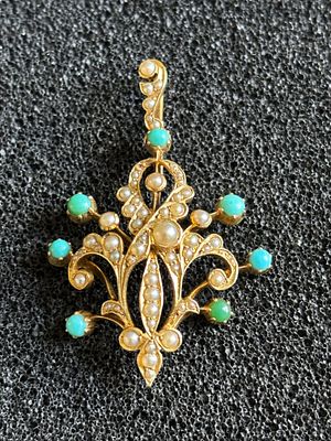 A 15 ct gold pendant decorated with seed pearls and turquoise (one stone replaced with a 