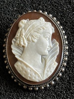 A cameo pendant / brooch of a lady in white metal mount weighing 6.85 gm