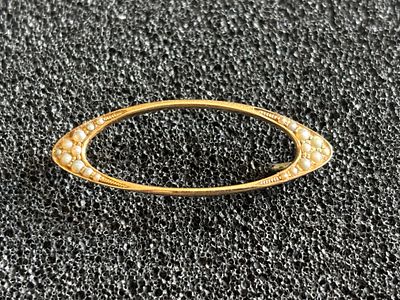 Aa oval brooch stamped 14 K decorated with seed pearls weighing 2.29 gm