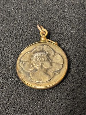 A yellow metal pendant with an Art Nouveau decoration to the reverse (the surround weighs 0.8 