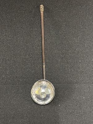 A white metal toddy ladle with wooden handle inset with a George IV coin
