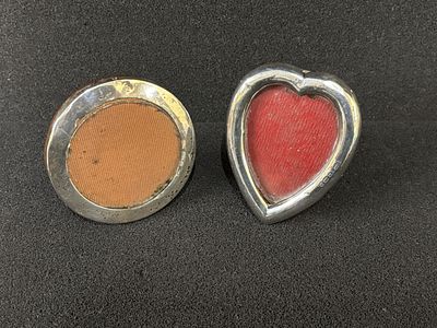 Two small HM Silver photo frames one circular (7 cm diameter) the other heart shaped (6 cm wide)