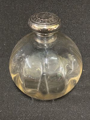 An ornate HM Silver topped scent bottle