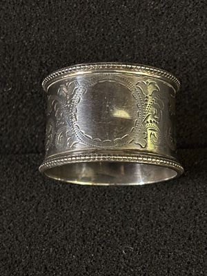 A decorative HM Silver napkin ring with a blank cartouche weighing 34.24 gm