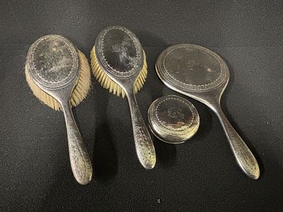 A four piece HM Silver dressing table set comprising two brushes, a mirror and a silver lid 