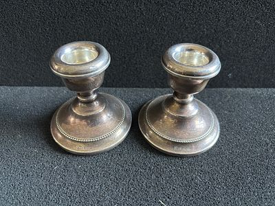 A pair of HM Silver candlesticks measuring 7 cm tall with loaded bases (195gm overall)