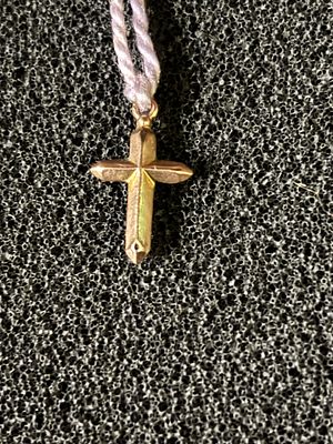 A very small 9ct gold crucifix weighing 0.27 gm