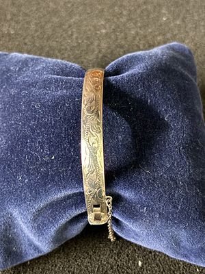 A HM Silver hinged bangle with safety chain weighing 22.3 gm