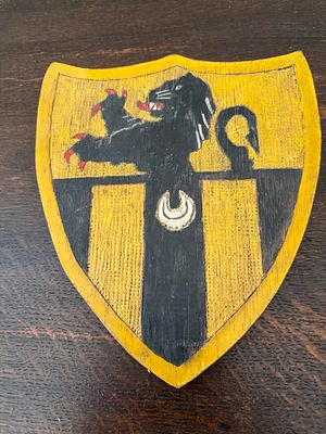 A Hand-Painted Heraldic Wooden Shield Plaque Depicting the Arms of Flanders and a Barry Field 