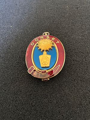 UK Dorset Enamel and Gold-Toned Metal Badge. An oval-shaped gold-toned metal and enamel badge or 