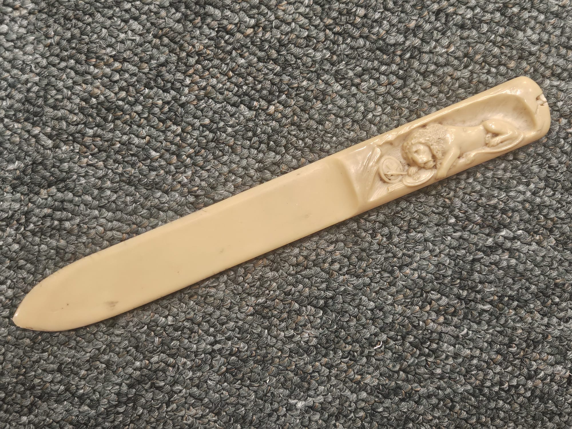 Carved bone page turner with relief lion handle