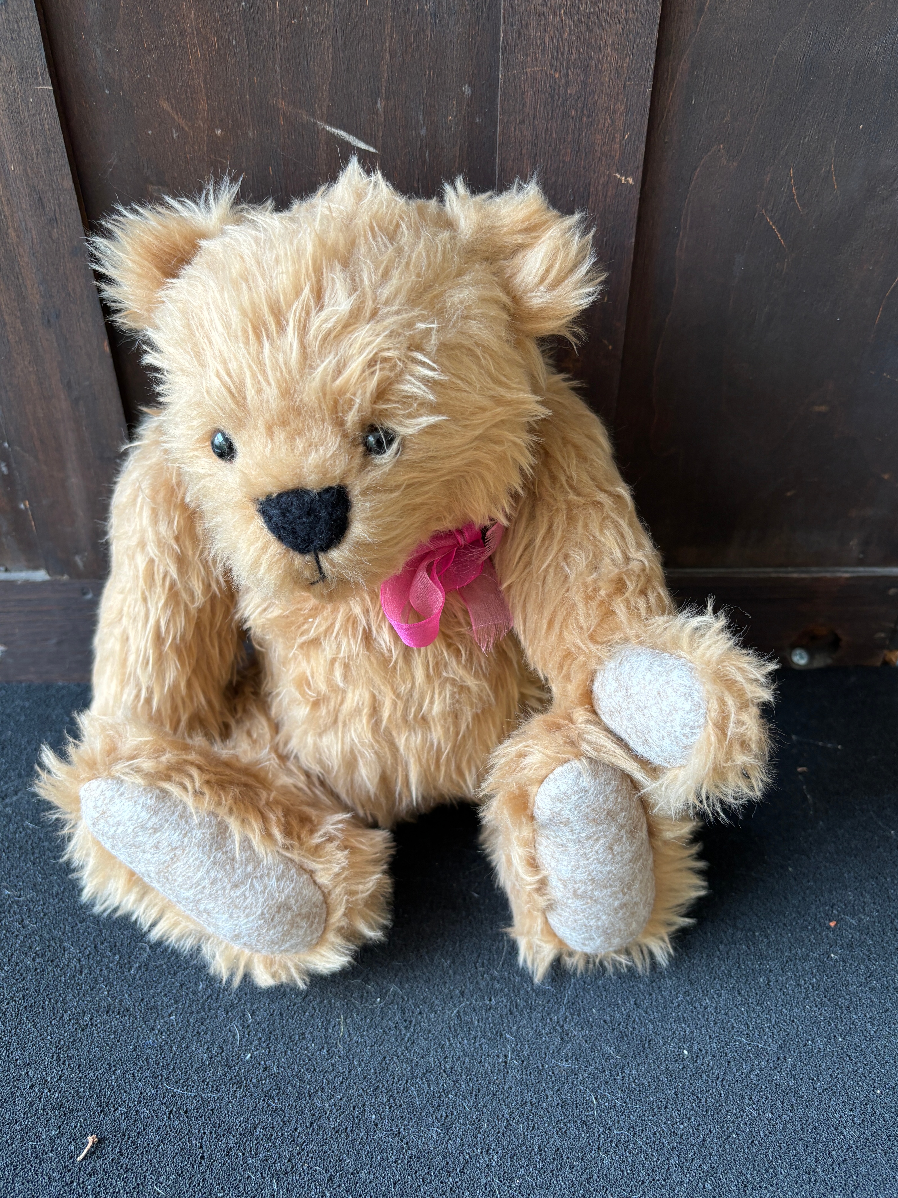 A five-way jointed shaggy golden-brown collector's teddy bear c 26 cm seated