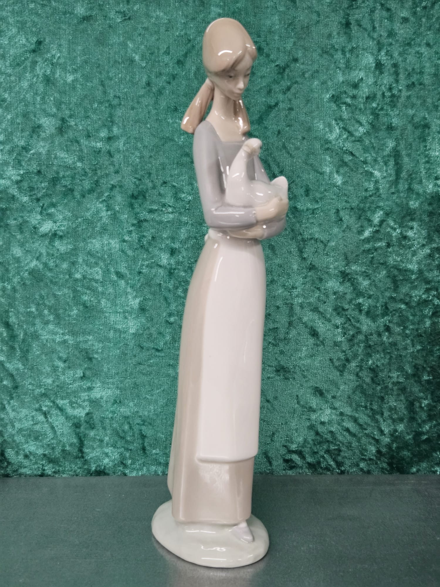 A Nao Spanish glazed porcelain figurine of a girl holding a goose