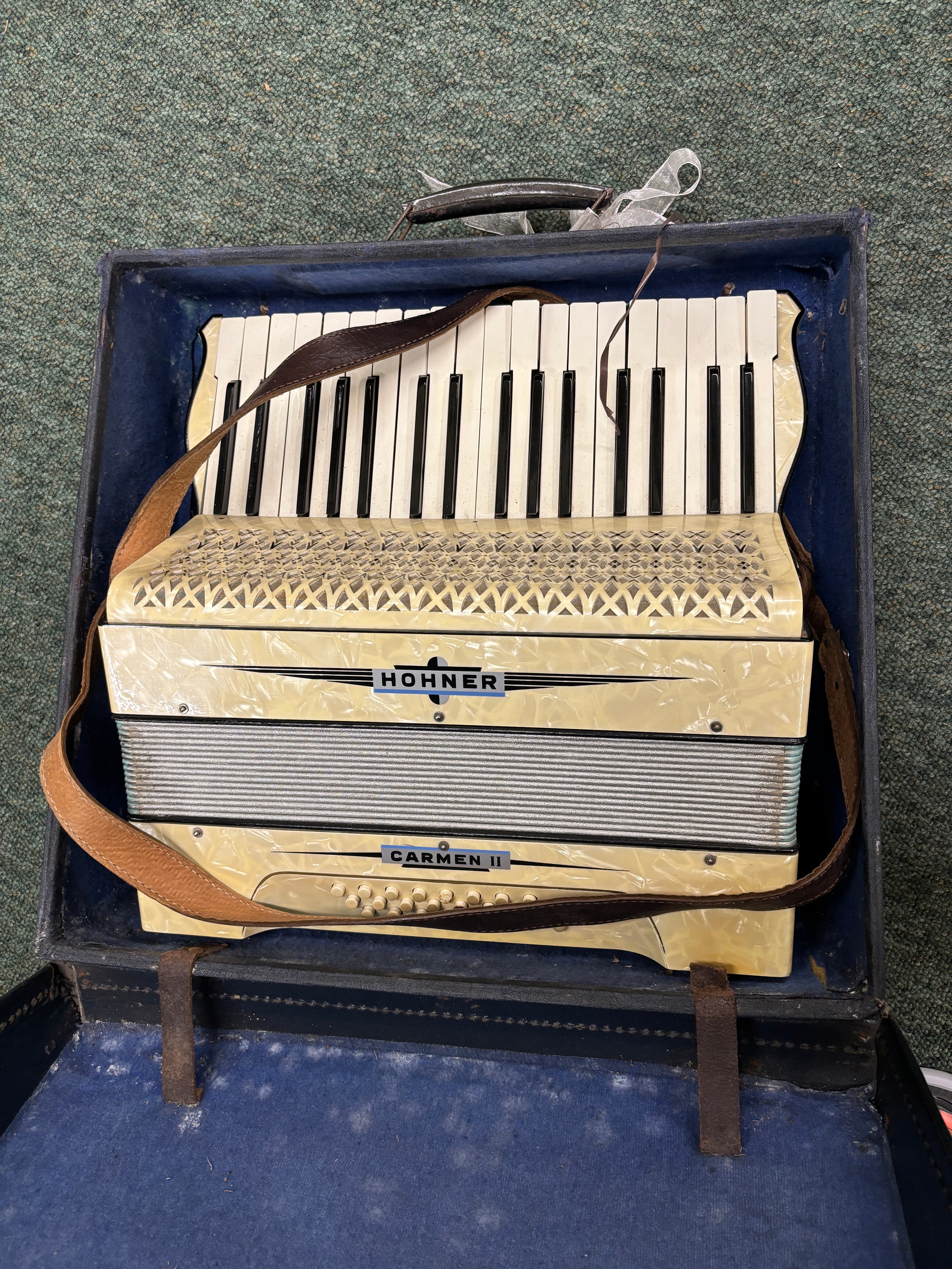 A Hohner Carmen II piano accordion in a blue hard-shell case
