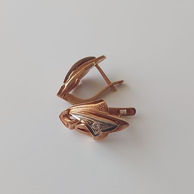 עגילי זהב אדום 14 קראט, חתומים 585 ועוד חתימות רוסיות ישנות, משובצים ביהלום בקוטר 2.47 מ"מ. 