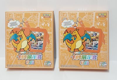 זוג מארזי פוקימון Charizard פתוחים עם קלף ומחזיק מפתחות ייחודי