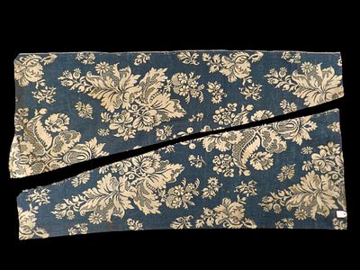 Two fragments of the same textile. Date unknown. A textile comprising two pieces of blue and 