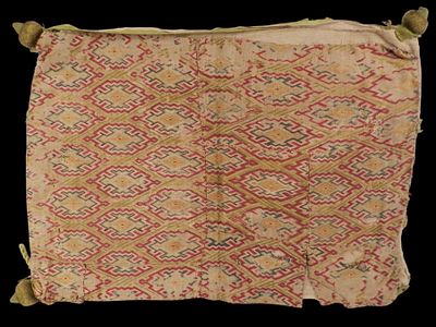 Cushion, c. 1600. A cushion featuring a design of diamond-shaped motifs bordered by fretwork 