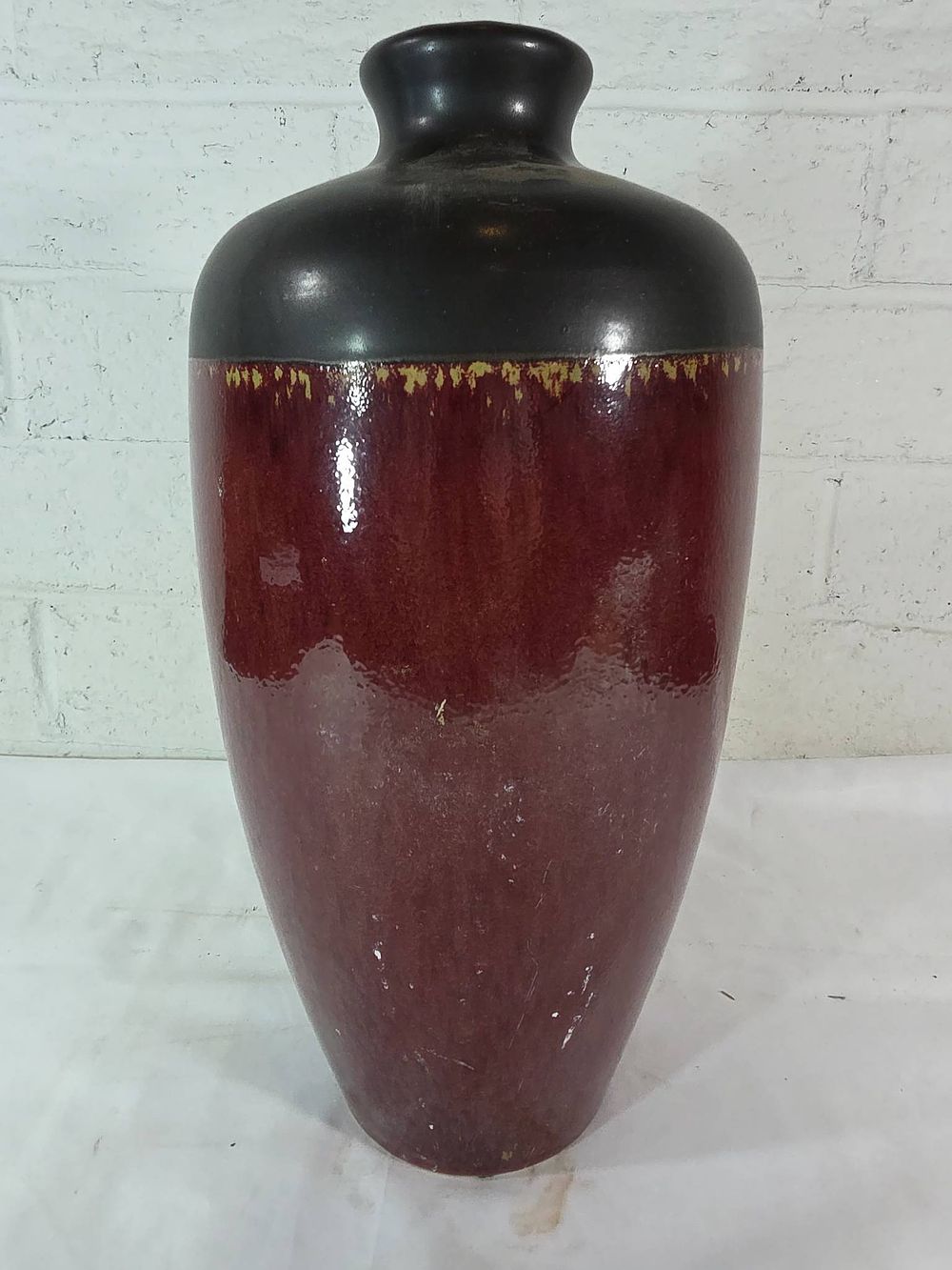 Red and Black Glazed Ceramic Vase. Ceramic vase with a tall, tapered form and a rounded narrow 