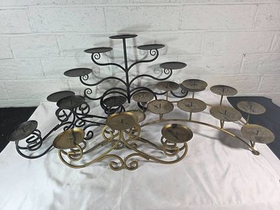 4 Metal Candelabras. Four metal candelabras in varying designs and sizes. Pieces include
