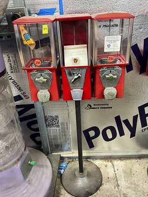 Red Triple-Head Coin-Operated Vending Machine. Triple-head coin-operated vending machine mounted 