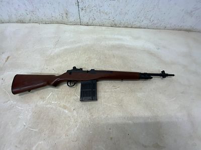 Toy Rifle with Brown Stock and Black Details. Toy rifle featuring a brown molded plastic stock 